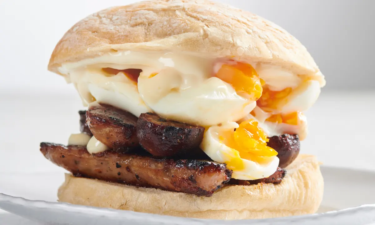 Browned sausages in a floury bun with boiled eggs